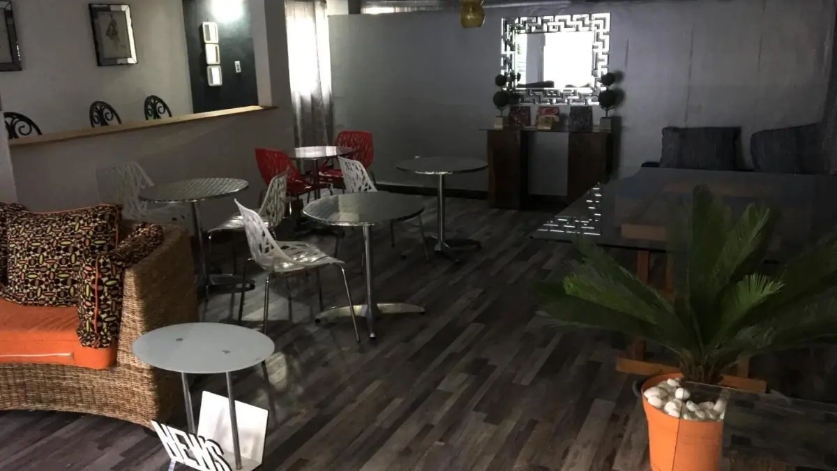 Sala de estar común de Serenade Lodging Rooms, con mesas y plantas